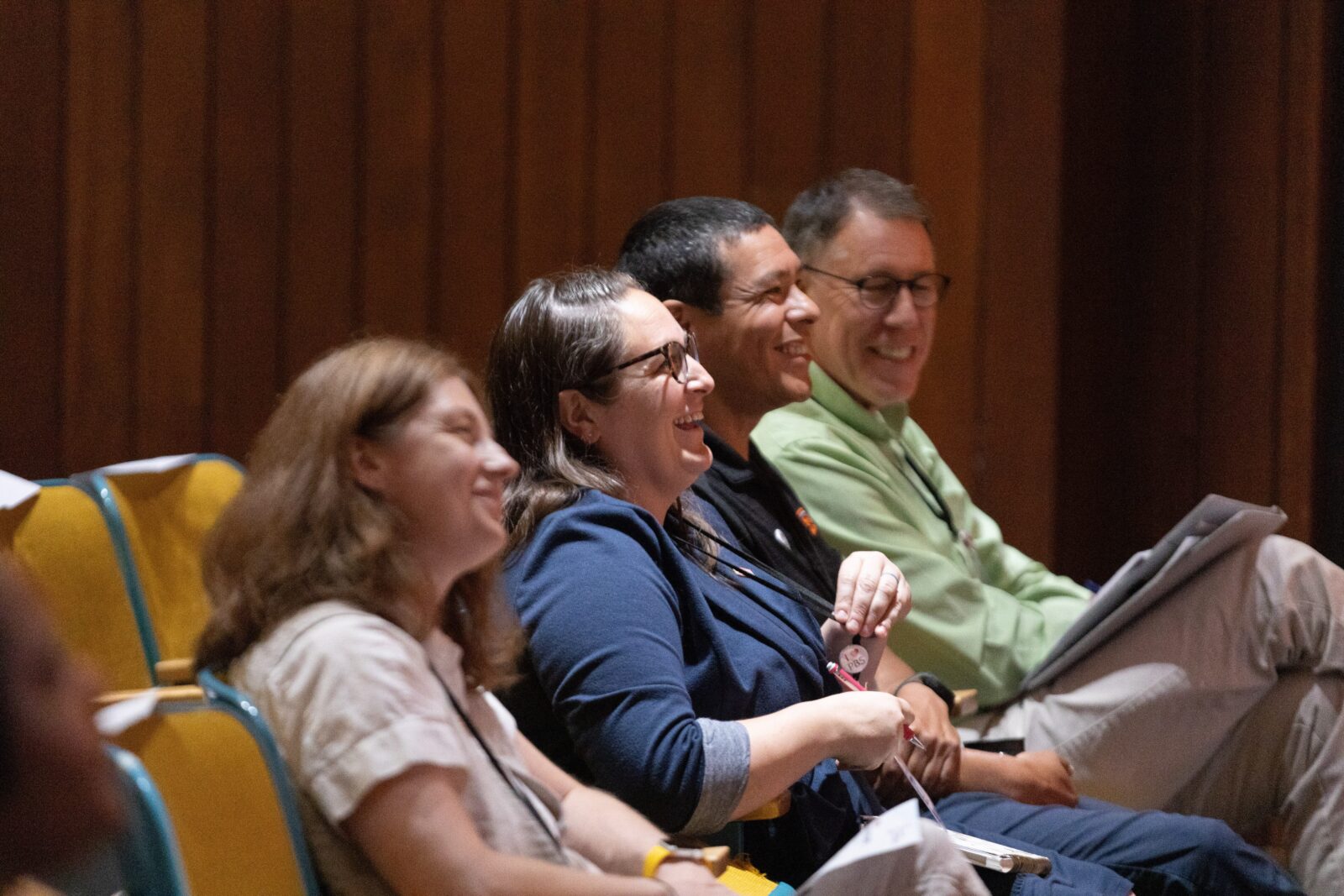 Four people in an audience engaged in WPM content at a recent summit. 