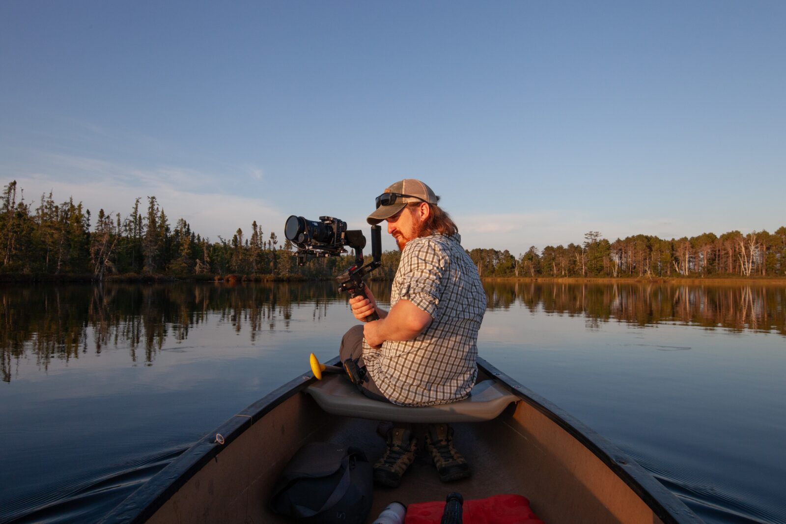 Camera operator on a boat in a peaceful lake recording for a WPM production.